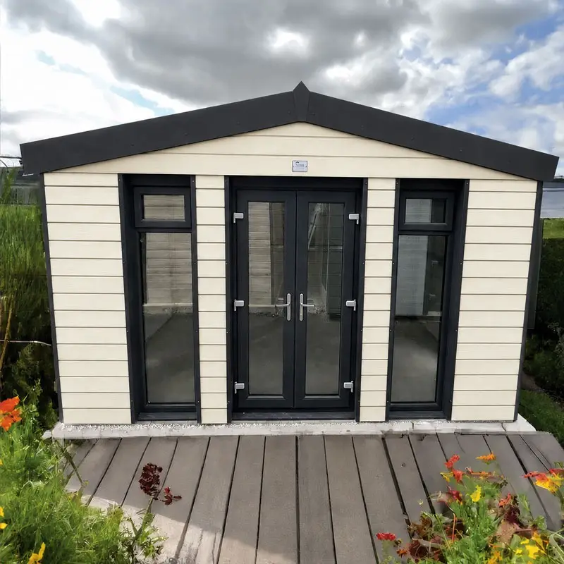 Small beige garden shed with black-framed glass doors and side windows on a wooden deck, under a cloudy sky