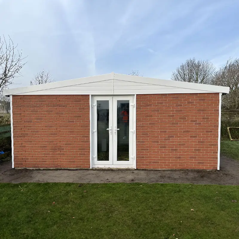 Brick garden shed with white-framed glass double doors and a white pitched roof
