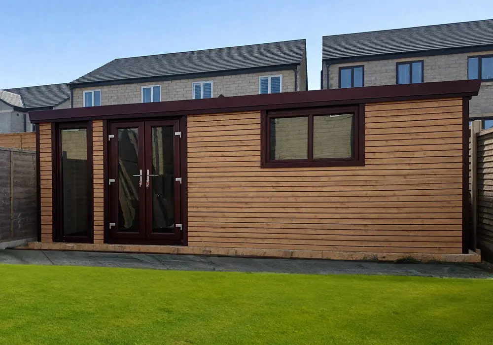 insulated-garDEN-ROOMS - All Seasons Steel Buildings Wooden garden shed with dark brown trim and double-glazed glass doors, set on a paved base in a fenced backyard.
