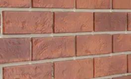 Close-up of a red brick wall with light gray mortar.
